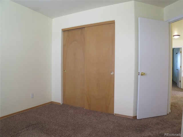 unfurnished bedroom with carpet flooring and a closet