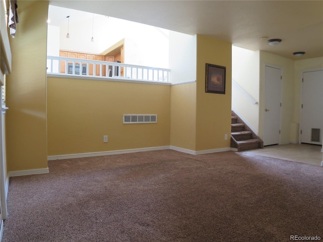 empty room featuring baseboards, visible vents, carpet flooring, and stairs