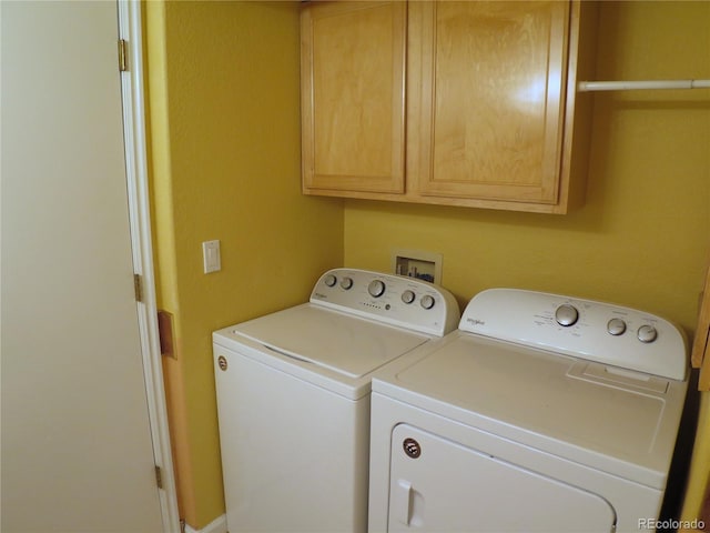 washroom with cabinet space and washer and clothes dryer
