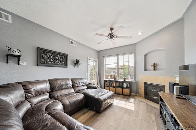 10787 Twenty Mile Rd Unit 205, Parker, CO 80134 - living area featuring light wood-style flooring, ceiling fan, a tiled fireplace, and lofted ceiling