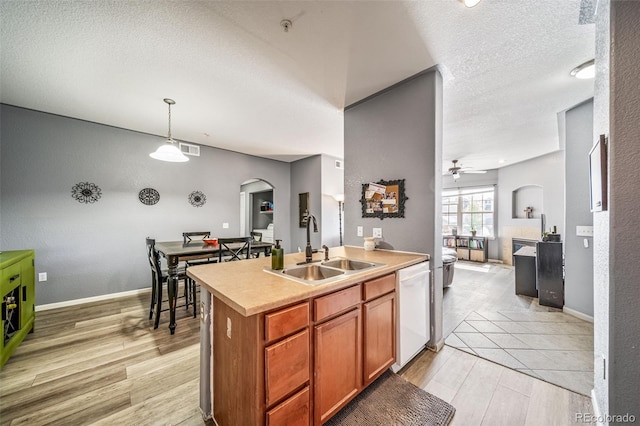 10787 Twenty Mile Rd Unit 205, Parker, CO 80134 - kitchen featuring a sink, arched walkways, white dishwasher, a textured ceiling, and light wood-style flooring