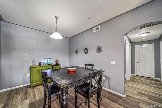 10787 Twenty Mile Rd Unit 205, Parker, CO 80134 - dining room featuring arched walkways, wood finished floors, and baseboards