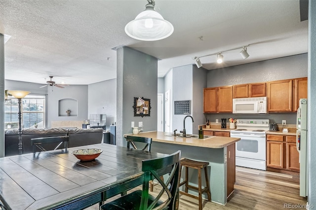 10787 Twenty Mile Rd Unit 205, Parker, CO 80134 - kitchen featuring a sink, white appliances, brown cabinets, light wood finished floors, and a ceiling fan