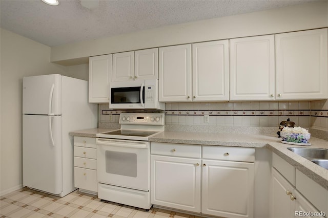 10883 Otis Cir, Westminster, CO 80020 - kitchen with white appliances, white cabinets, light countertops, a textured ceiling, and recessed lighting