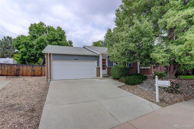 10883 Otis Cir, Westminster, CO 80020 - view of front of home with brick siding, an attached garage, driveway, a shingled roof, and a gate