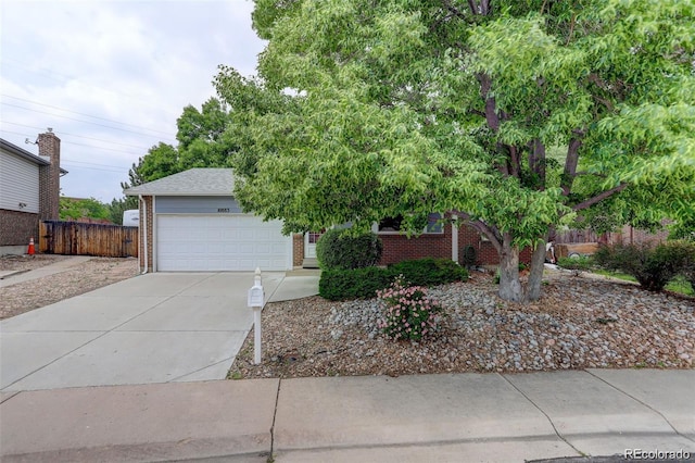 10883 Otis Cir, Westminster, CO 80020 - obstructed view of property with driveway, brick siding, and a garage