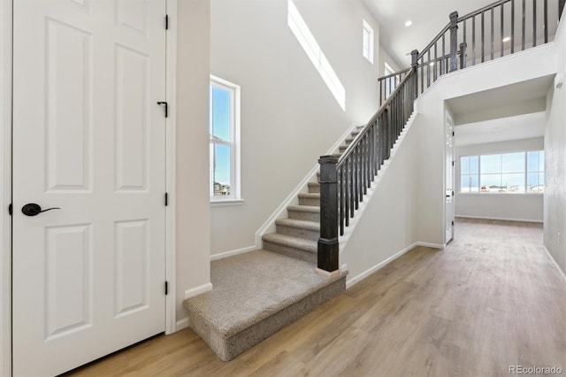 stairway featuring a high ceiling and wood-type flooring