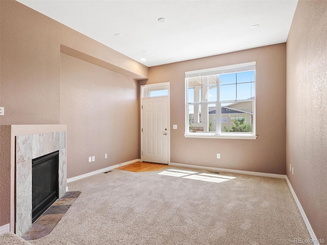 unfurnished living room featuring light colored carpet and a fireplace