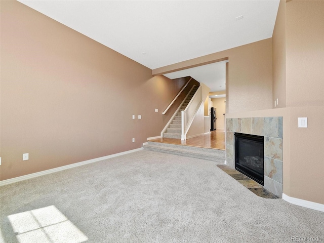 unfurnished living room with light colored carpet and a fireplace