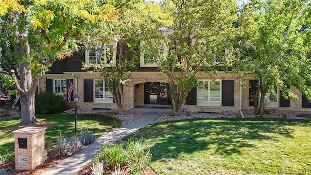 view of front of property featuring a front lawn and brick siding