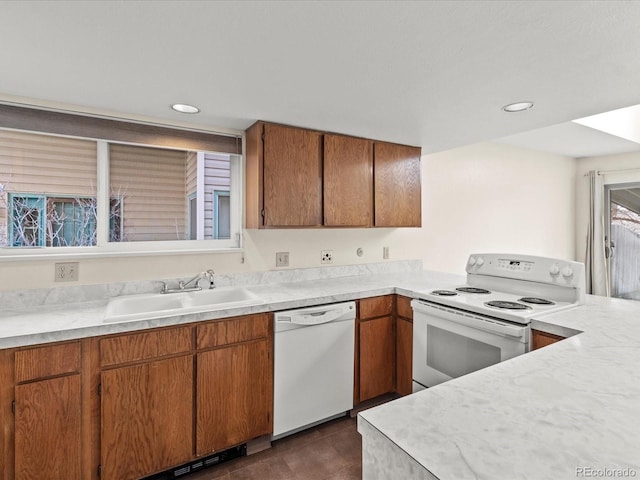 kitchen featuring brown cabinetry, white appliances, light countertops, and a sink