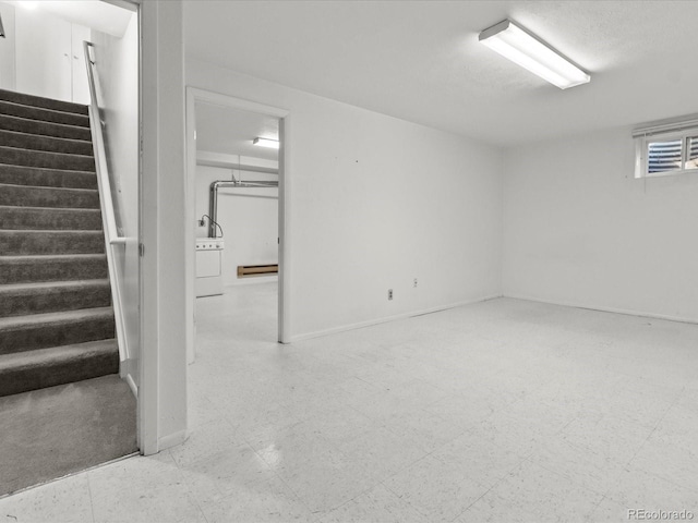 below grade area with light floors, stairway, and washer / dryer