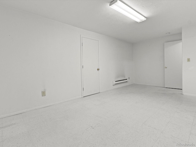 unfurnished room with light floors, baseboard heating, and baseboards