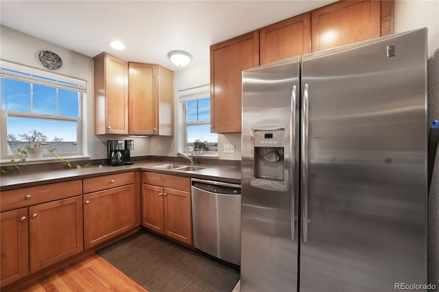 1544 Cottonwood Ave, Lafayette, CO 80026 - kitchen with brown cabinetry, wood finished floors, a sink, stainless steel appliances, and dark countertops