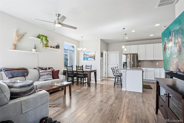 19733 W 93rd Ln Unit A, Arvada, CO 80007 - living room featuring light wood-style floors, ceiling fan, a chandelier, recessed lighting, and baseboards