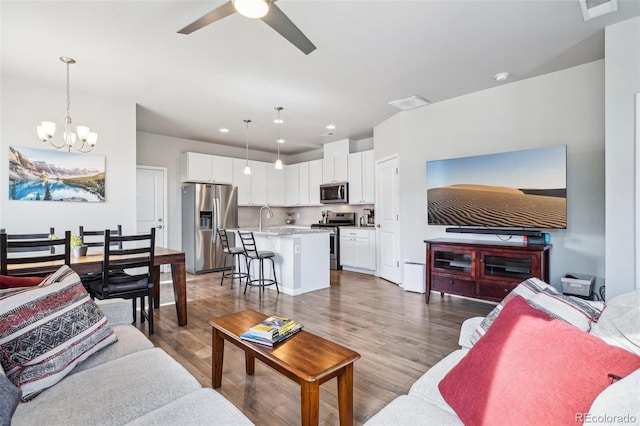 19733 W 93rd Ln Unit A, Arvada, CO 80007 - living area with a chandelier, ceiling fan, wood finished floors, and recessed lighting