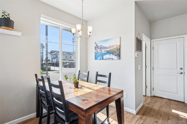 19733 W 93rd Ln Unit A, Arvada, CO 80007 - dining room featuring a chandelier, light wood-style floors, and baseboards