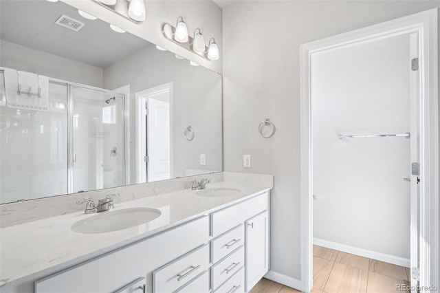 19733 W 93rd Ln Unit A, Arvada, CO 80007 - bathroom featuring double vanity, a stall shower, and baseboards