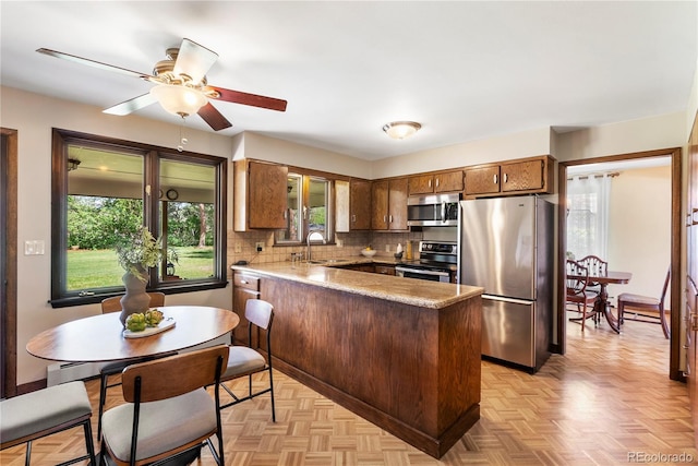 5503 W Colorado Ave, Lakewood, CO 80232 - kitchen featuring a sink, appliances with stainless steel finishes, a peninsula, and a healthy amount of sunlight