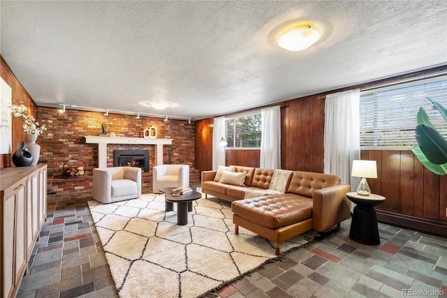 5503 W Colorado Ave, Lakewood, CO 80232 - living area with brick wall, a fireplace, wood walls, and a textured ceiling