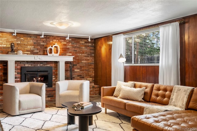 5503 W Colorado Ave, Lakewood, CO 80232 - living area featuring track lighting, a textured ceiling, wooden walls, and a fireplace