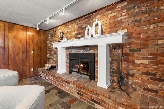 5503 W Colorado Ave, Lakewood, CO 80232 - living area with a brick fireplace, a textured ceiling, rail lighting, and wood walls