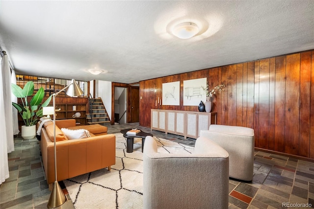 5503 W Colorado Ave, Lakewood, CO 80232 - living area with stairs, wooden walls, a textured ceiling, and stone finish flooring