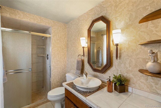 5503 W Colorado Ave, Lakewood, CO 80232 - full bath with vanity, tile patterned floors, a shower stall, and toilet