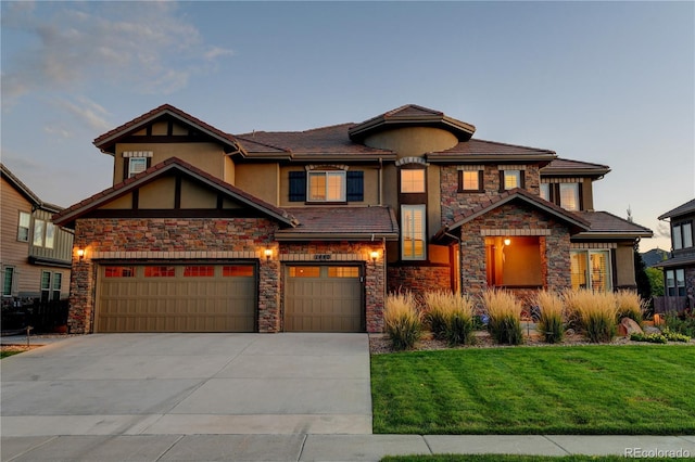 view of front of home with stucco siding, driveway, an attached garage, and a front lawn