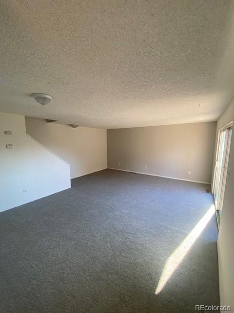 carpeted spare room featuring a textured ceiling