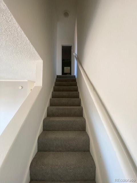 stairway with a textured ceiling