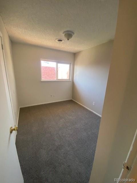 carpeted spare room with a textured ceiling