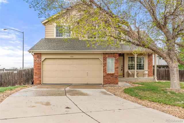 traditional-style home featuring fence, covered porch, driveway, and brick siding