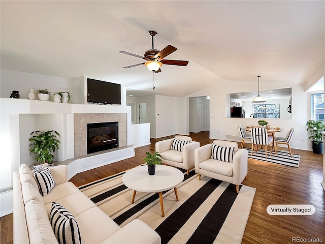 living room featuring hardwood / wood-style flooring, ceiling fan, and vaulted ceiling