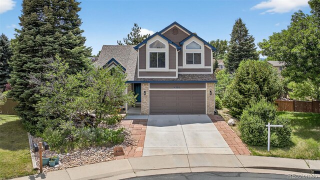 4386 W Deertrail Ct, Castle Rock, CO 80109 - view of front of home with brick siding, driveway, an attached garage, and roof with shingles