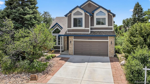 4386 W Deertrail Ct, Castle Rock, CO 80109 - view of front of house featuring brick siding, driveway, an attached garage, and a shingled roof