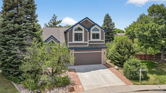 4386 W Deertrail Ct, Castle Rock, CO 80109 - view of front of house with driveway, roof with shingles, a garage, and brick siding