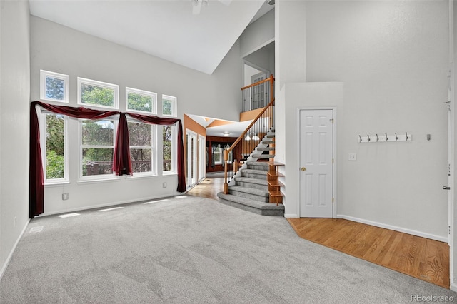 4386 W Deertrail Ct, Castle Rock, CO 80109 - carpeted entryway with high vaulted ceiling, stairs, and wood finished floors