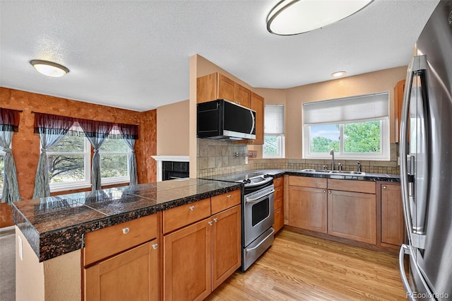 4386 W Deertrail Ct, Castle Rock, CO 80109 - kitchen featuring appliances with stainless steel finishes, tile counters, plenty of natural light, a peninsula, and a textured ceiling