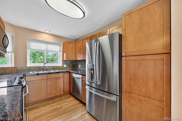 4386 W Deertrail Ct, Castle Rock, CO 80109 - kitchen featuring appliances with stainless steel finishes, light wood-style flooring, and backsplash