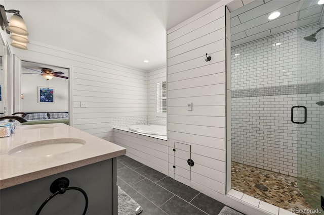 full bathroom with double vanity, tile patterned floors, a garden tub, a shower stall, and a sink