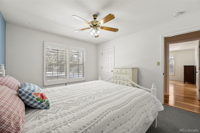 bedroom with wood finished floors, a ceiling fan, and baseboards