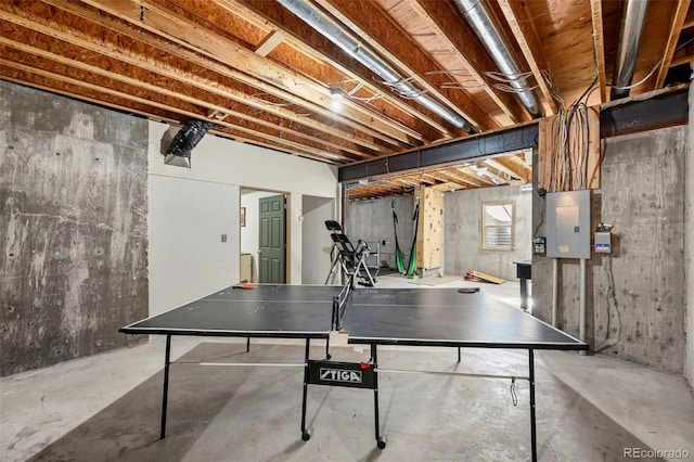 playroom with unfinished concrete flooring and electric panel