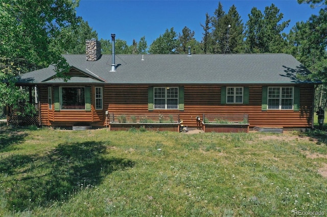 view of front of house featuring entry steps, a garden, a chimney, and a front lawn