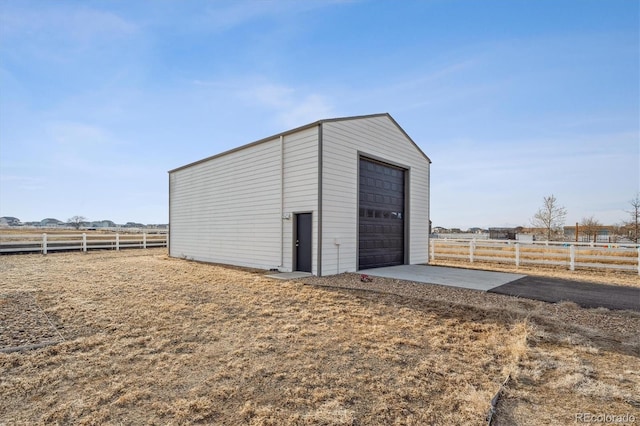 view of outbuilding featuring an outbuilding, a rural view, and fence