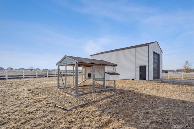 view of poultry coop featuring a rural view and fence