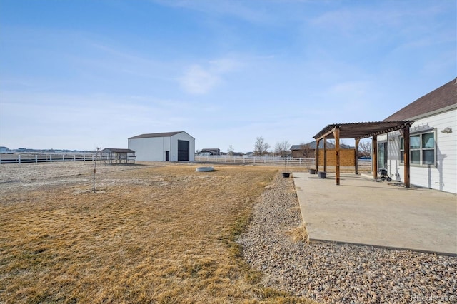 view of yard with an outbuilding, fence, an outdoor structure, a patio area, and a pergola