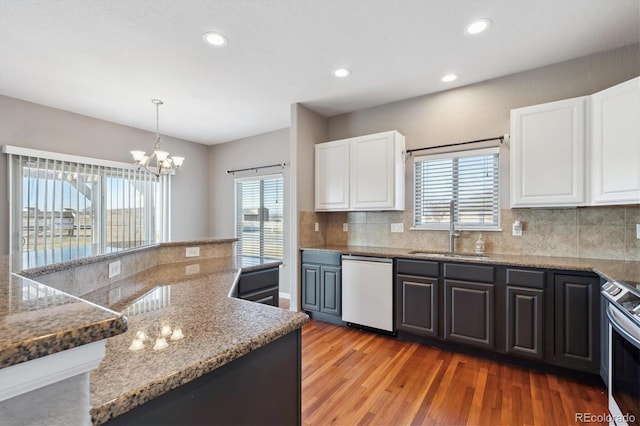 kitchen featuring decorative backsplash, dishwashing machine, light wood-type flooring, stainless steel range with electric stovetop, and a sink