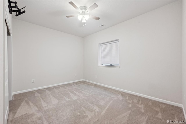 empty room featuring a ceiling fan, carpet, visible vents, and baseboards