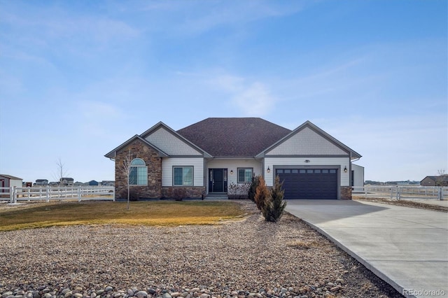 craftsman-style house with a garage, stone siding, fence, and a front yard